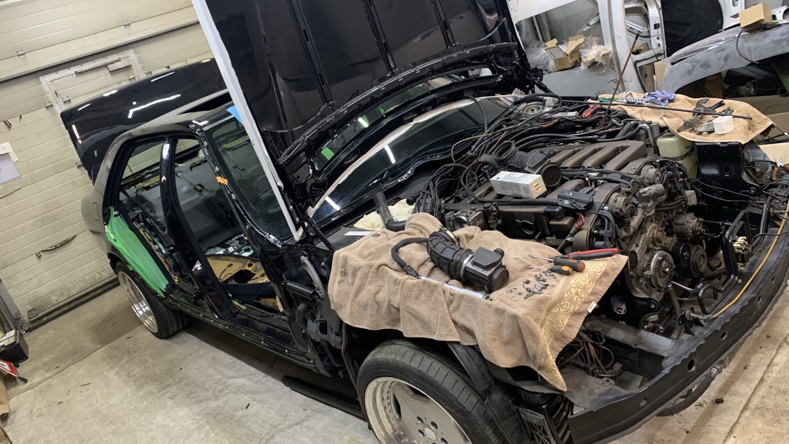 Открытый моторный отсек Mercedes-Benz W140 на подъёмнике в клубном гараже